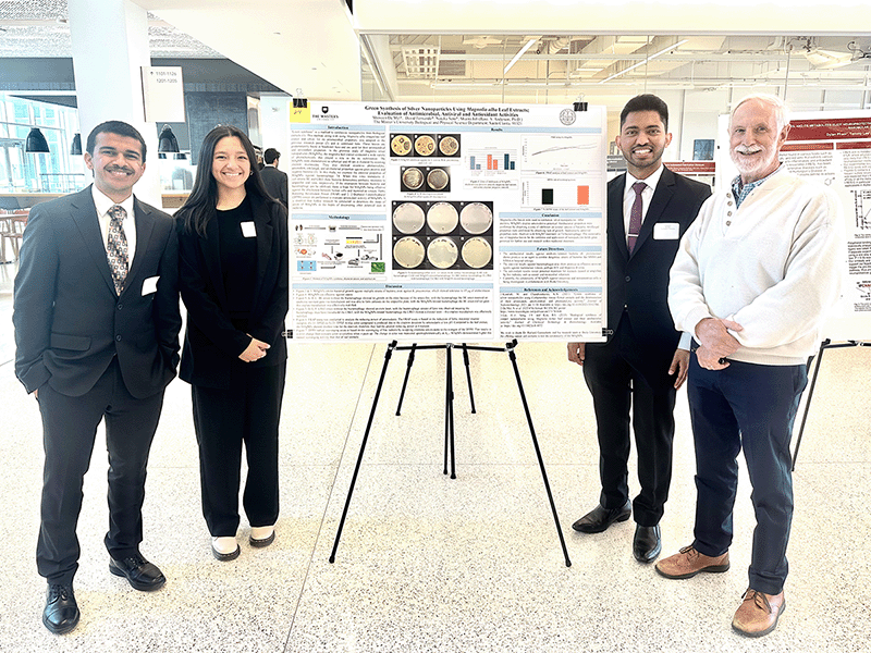 Students and faculty stand next to their poster