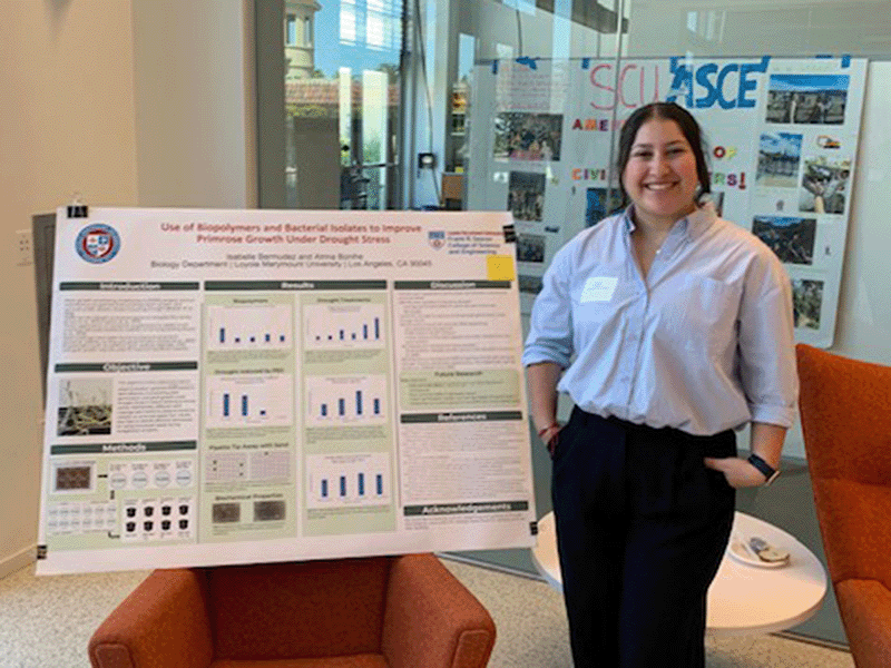 A student stands by her poster