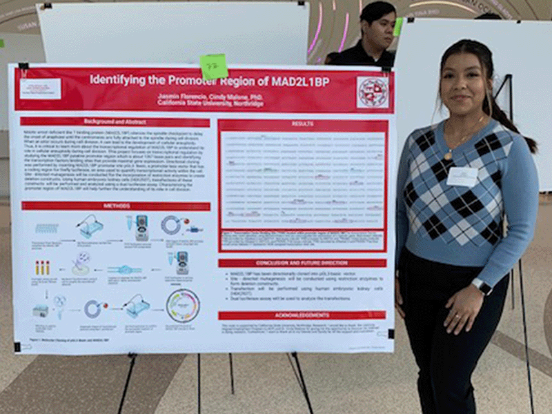 A student stands by her poster