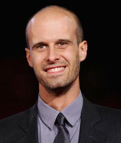 A smiling man in a suit and tie.