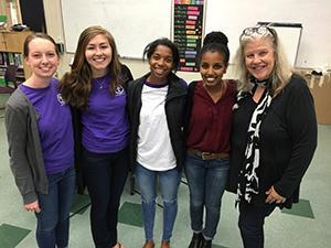 Five smiling individuals standing indoors, titled 'Engaged Students 6'.