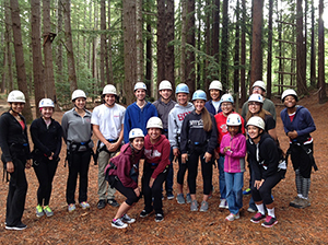 A group of people wearing helmets in a forest.