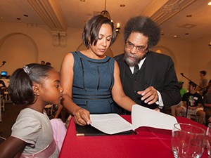 A man and woman read a document as a child watches.