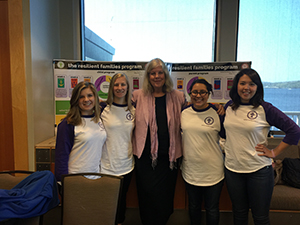 Alt text: Four people standing together in front of an informational booth.