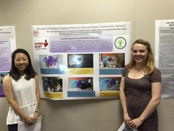 Two women standing beside a scientific poster presentation.