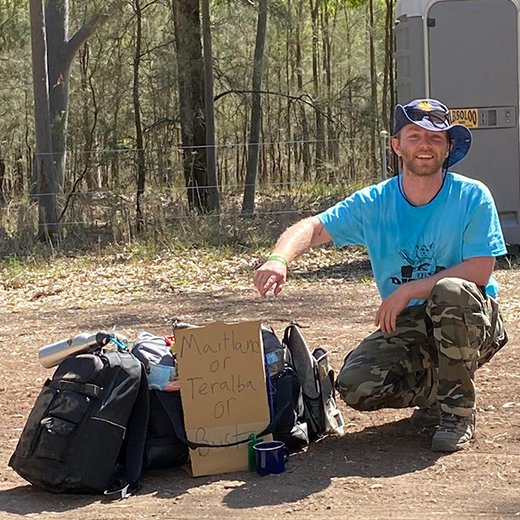 Brendan viewed through a car window, outdoors next to his equipment.