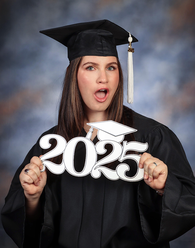 Caitlin Gronowki in black graduatios cap and gown holding a 2025 cutout