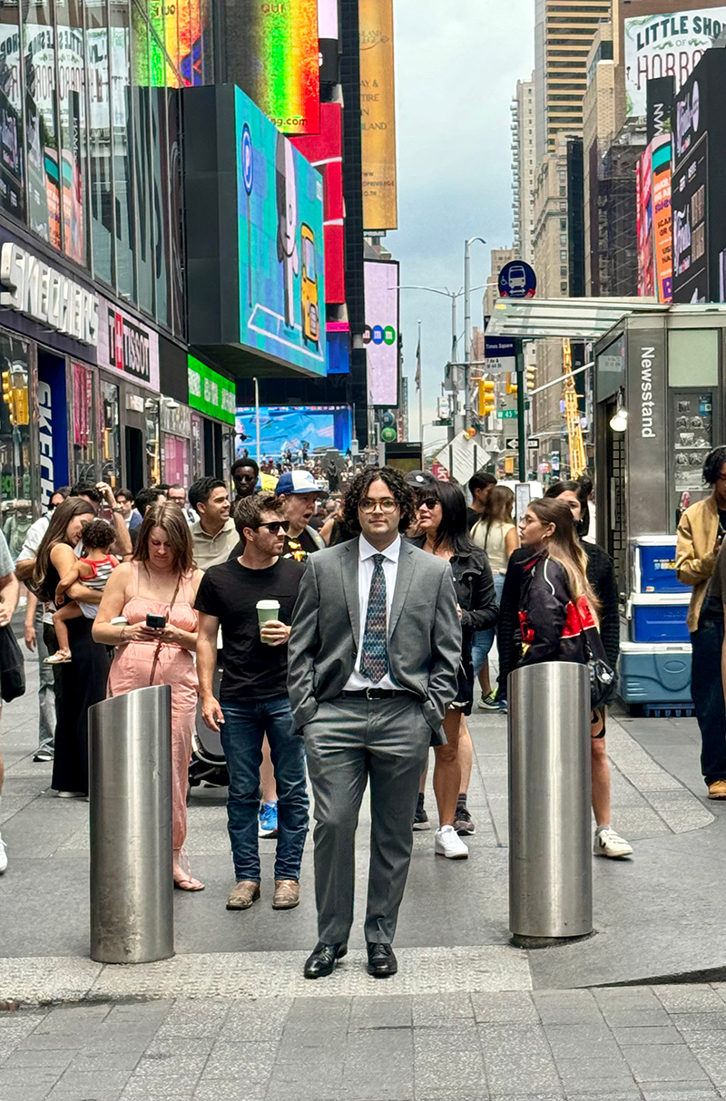 Adrian Machado at a cross walk with many others.