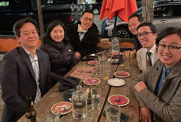 Juliana Chang sitting at an outdoor table with five other participants.