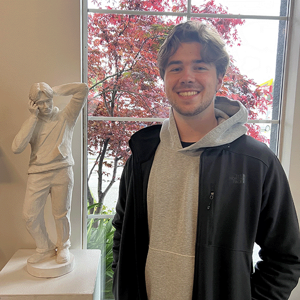 Charlie DiNapoli standing next to his sculpture