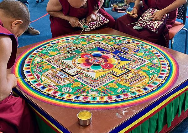 Monks from the Tashi Lhunpo Monastery finish a sand mandala