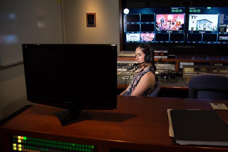 A person working at a computer with multiple screens in a control room.