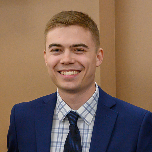 Evan Baerg holding the 2025 DeNardo Senior Prize award