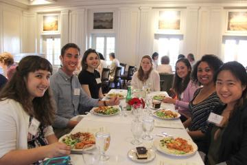 A group of people eating at a long table indoors. 