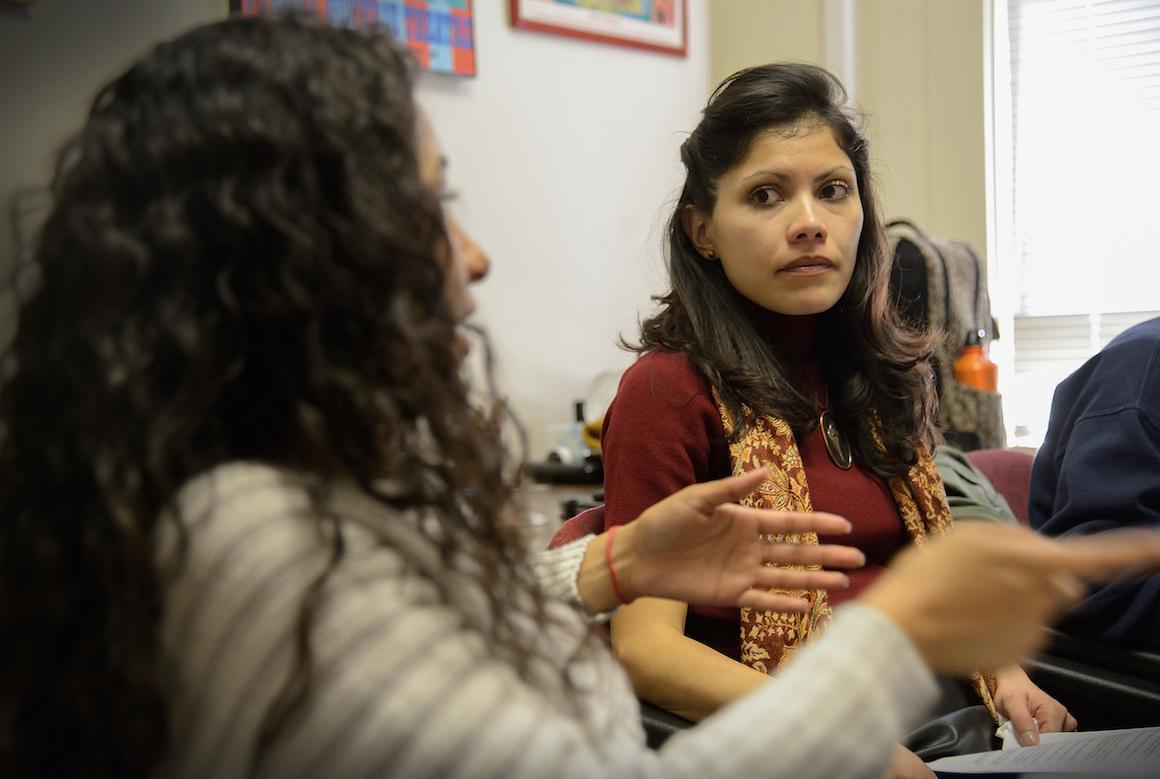 Two women discussing something in a classroom setting.