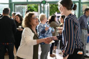 A community partner shaking hands with a current student