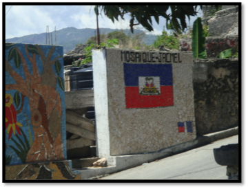 Concrete wall with a Haitian flag mural and text 
