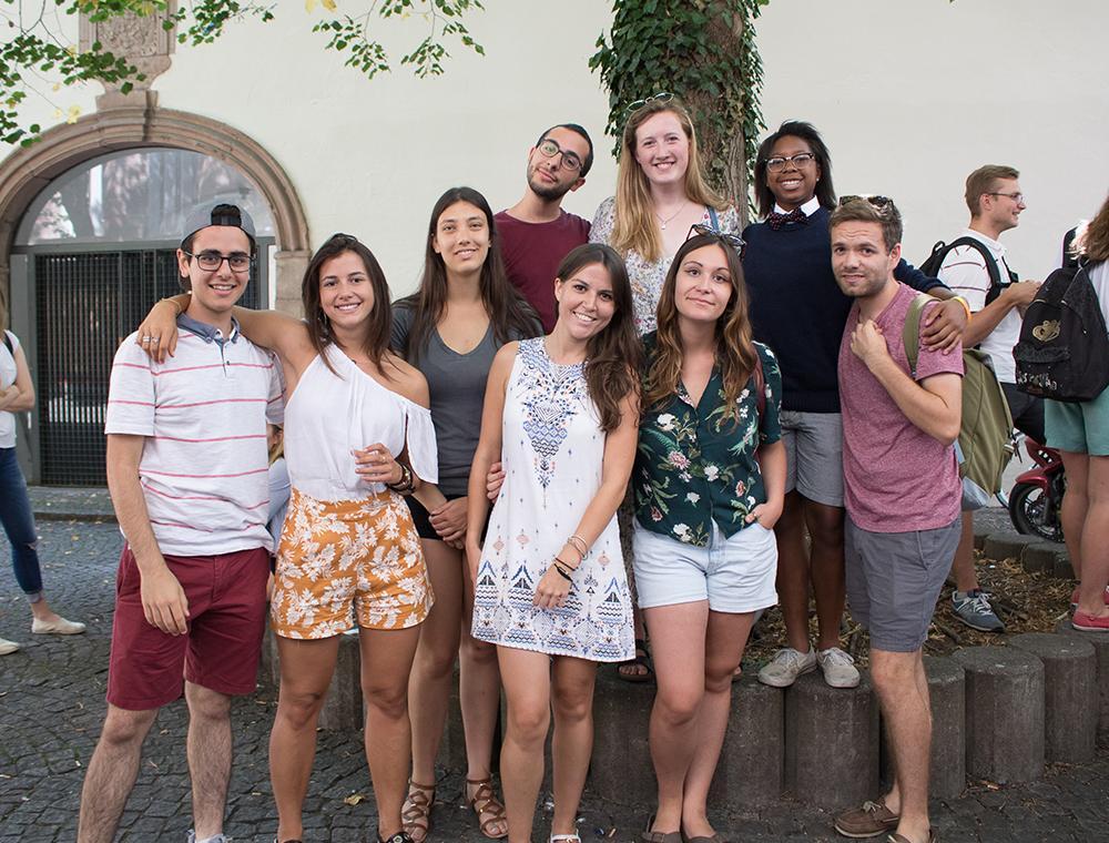 A group of people posing outdoors in front of a building.