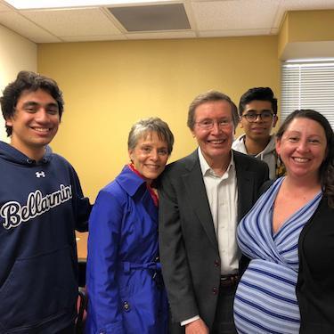 A group of five people smiling indoors.