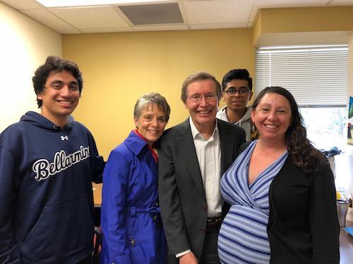 A group of five people smiling indoors.