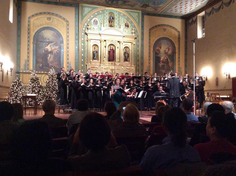 A concert choir performing in a church with an audience.