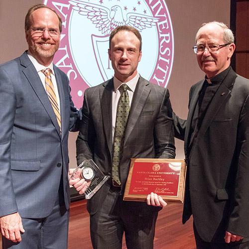 Professor Brian Buckley holding his award and plaque