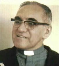 A man wearing glasses and a clerical collar smiles.