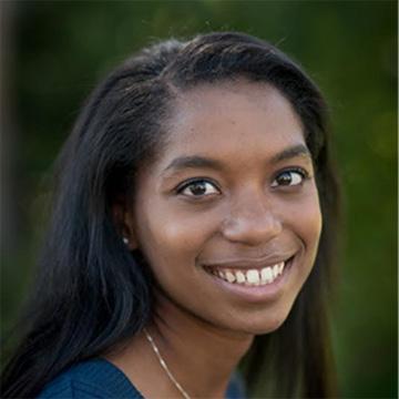 A person smiling with a green background.