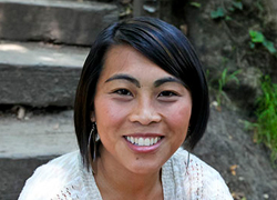 Smiling person sitting on outdoor steps.