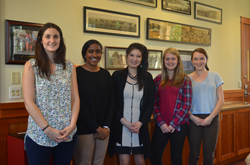 Wudunn with students standing in a hallway lined with framed pictures.