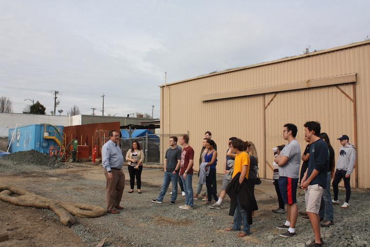 Group of people discussing construction plans at a building site.