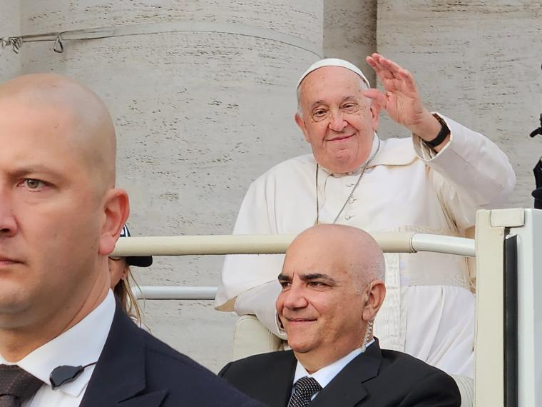 Pope Francis in the popemobile waving.