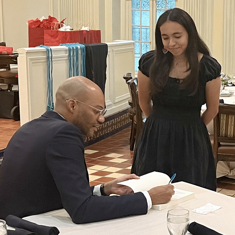 Dr. Maththew Clair signs his book for a student