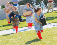 Migrations outdoor dance piece by David Popalisky with 5 female dancers carrying suitcases and boxes