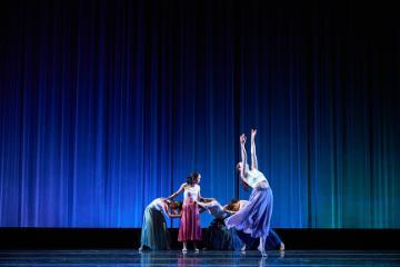 4 female dancers, one with arms outstretched