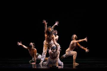 Group of dancers together with arms outstretched