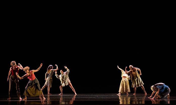 Groupings of dancers dressed as migrant workers