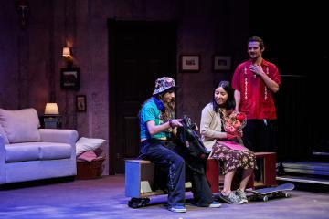 High-school age students, 2 female, and 1 male with flowers