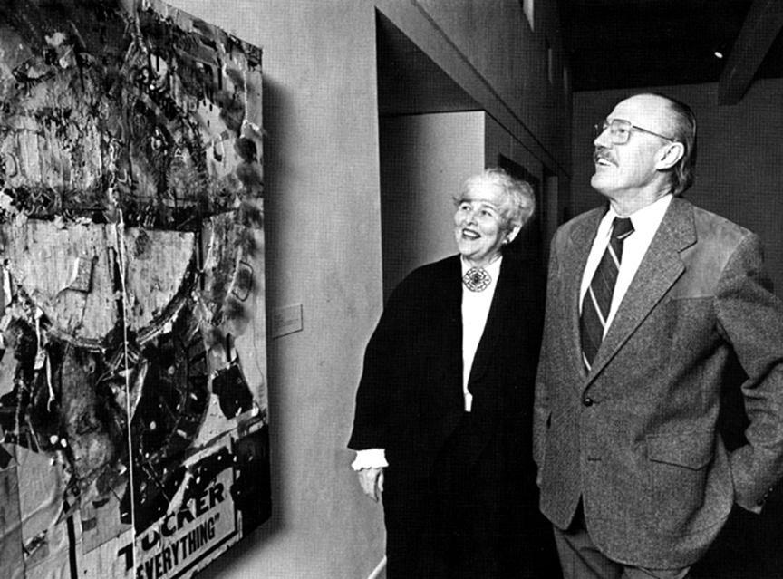 Portrait of Paula and Phillip Kirkeby standing by a Bruce Conner assemblage.