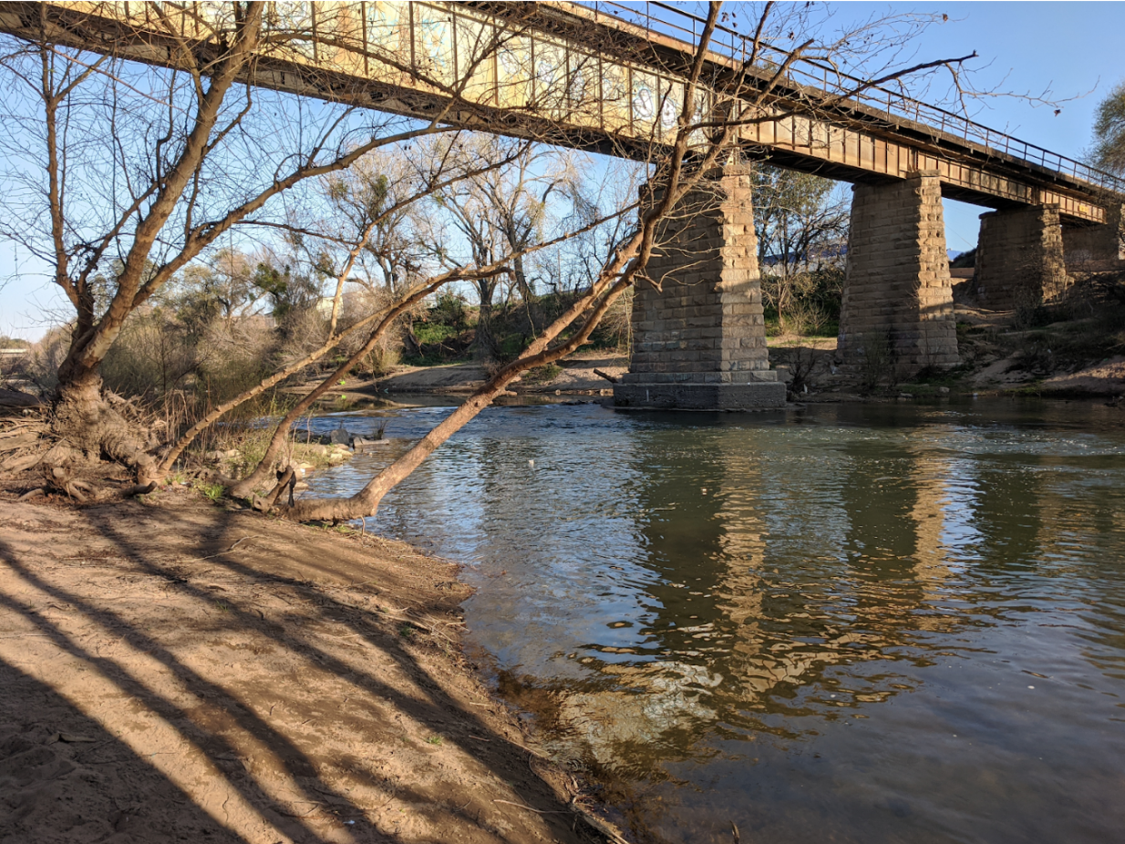 A bridge over a river surrounded by trees.