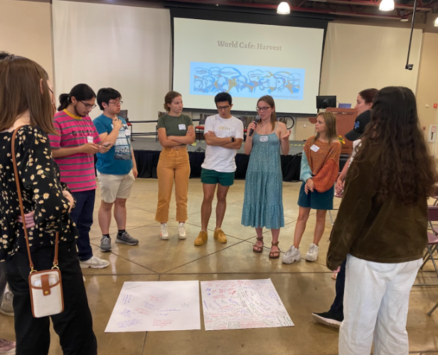 image of students standing around two posters on the floor