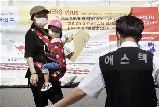 A person carrying a child walks past a police officer. image link to story