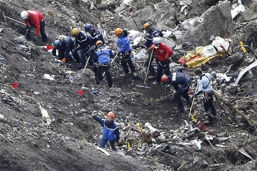 Rescuers search through debris on a mountainside.