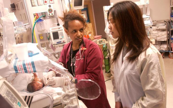 Student observing a nurse in the NICU