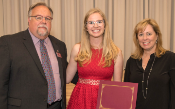 Three people standing; Madeline Eiken holding Markkula Prize award.