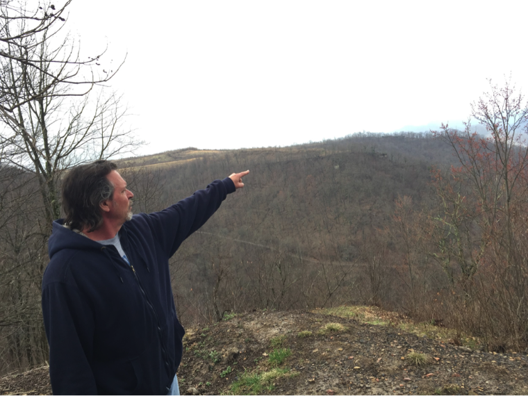 Tom Breiding points to future mining sites, as he leads a group of Santa Clara University students [6]. 