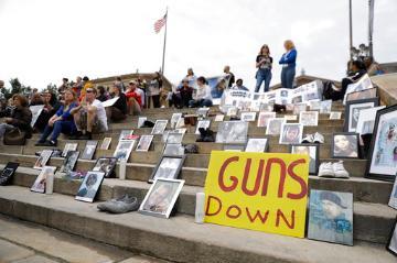People holding signs and gathering at a gun violence rally.