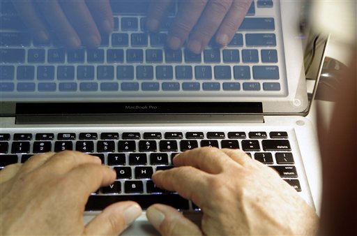 Hands typing on a laptop with code on the screen. image link to story