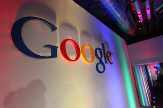 Google logo on a wall with colorful lighting effects.