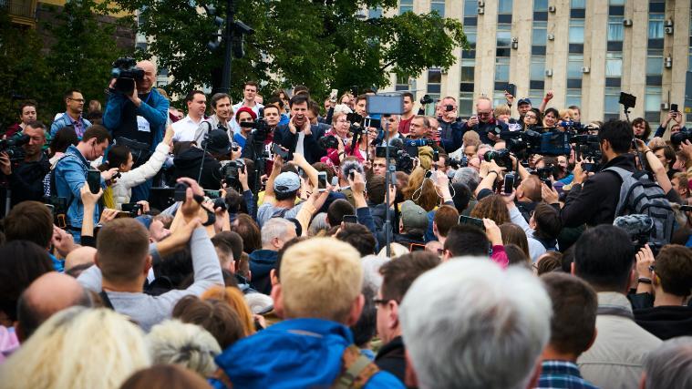 Reporters and large crowd of people.